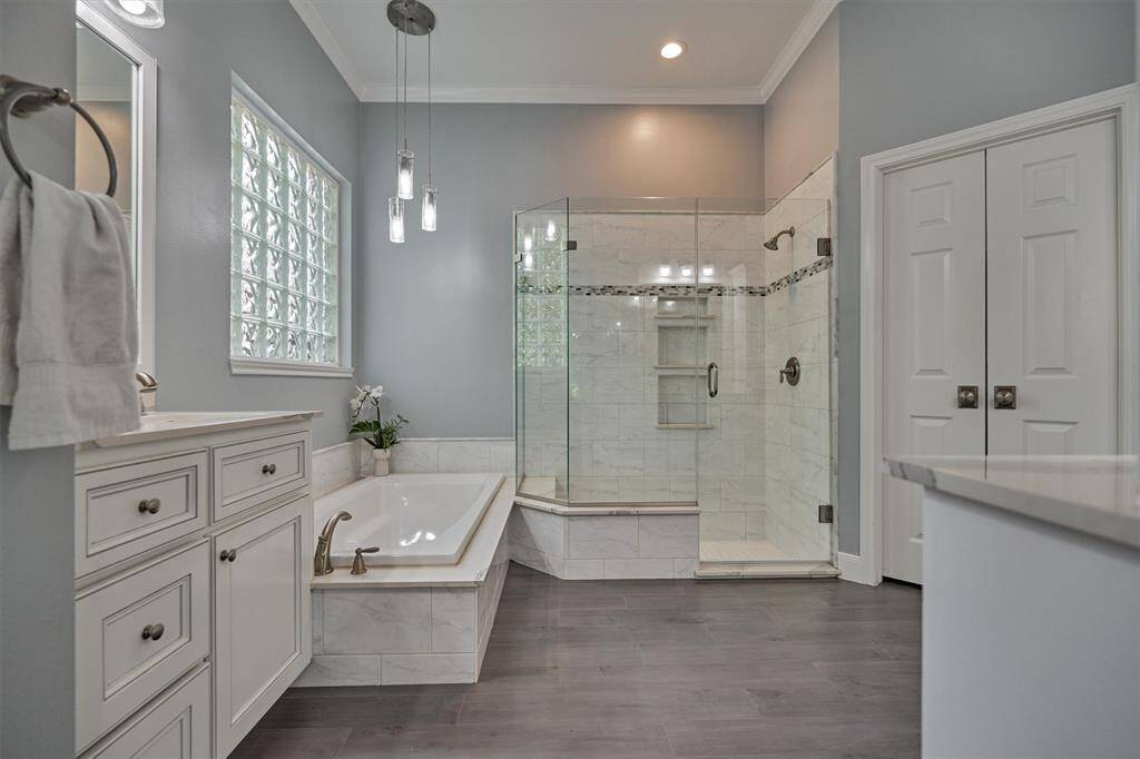 Note the updated flooring, enlarged shower, Hollywood-style soaking tub, raised vanities, modernized lighting, and more!