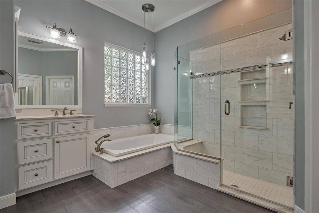 Plenty of storage space in this spa-like bathroom with custom cabinetry, dual sinks, and linen closet!