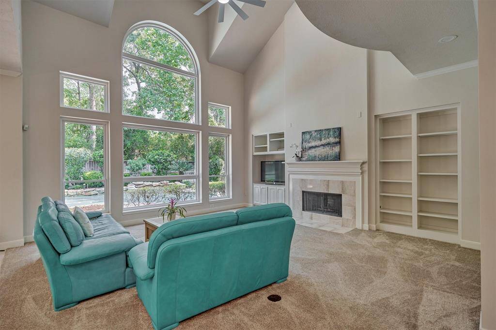 This dedicated home office is framed with a high ceiling, beautifully appointed bay windows, and built-in bookcase.
