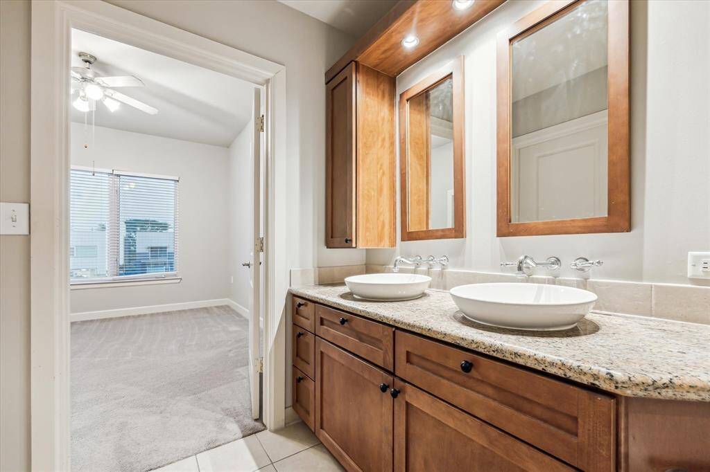The primary bath features double sinks with designer mirrors, generous countertop space, and ample cabinetry!