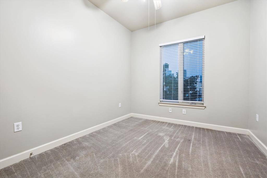 Secondary bedroom also features neutral paint, carpet & ceiling fan with great views of downtown!  Located on the other side of the common areas from the primary bedroom, each space is afforded their own privacy.