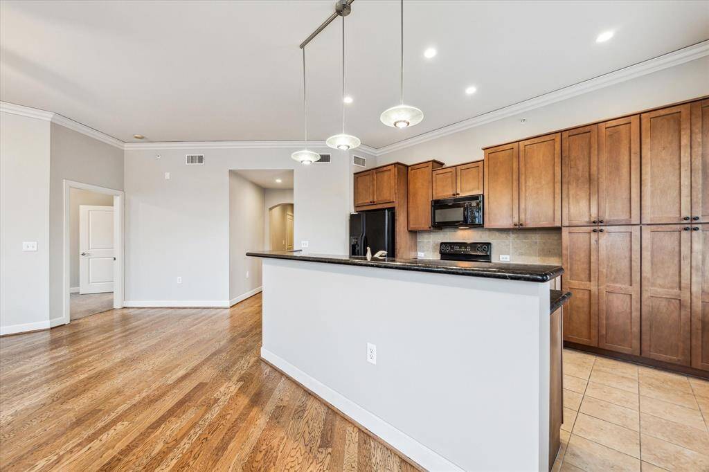 A stylish breakfast bar anchors the kitchen, highlighted by modern pendant lighting that adds a chic, contemporary touch to the open living space.