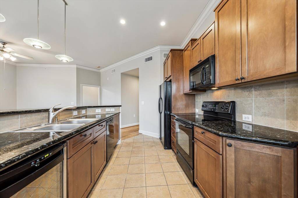 This view of the kitchen shows the wine refrigerator to the left of the sink.