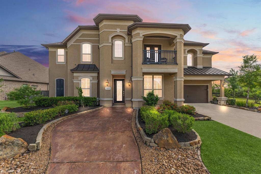 This striking two-story home features an elegant façade, spacious front yard, and landscaped garden. The property includes a covered balcony, a well-lit entrance, and a large driveway leading to a double garage.