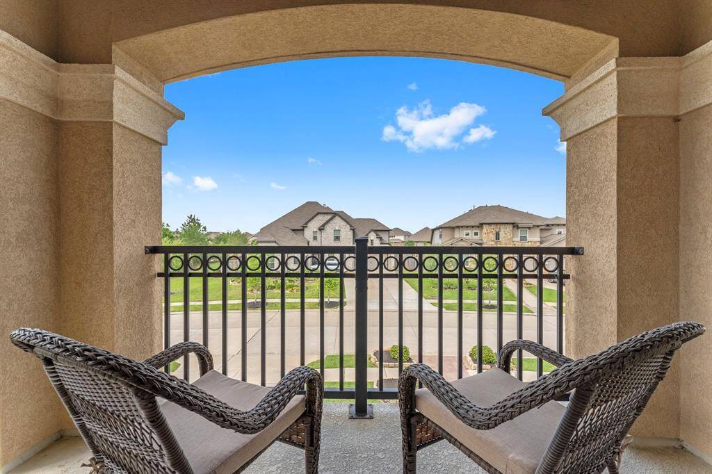 This photo showcases a cozy balcony offering a pleasant view of a suburban neighborhood. Ideal for relaxing and enjoying the outdoors.
