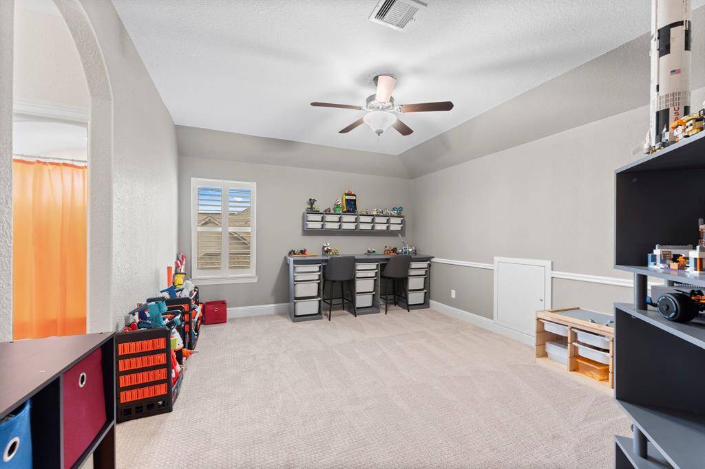 Bright, spacious room features a ceiling fan with a bathroom connected.
