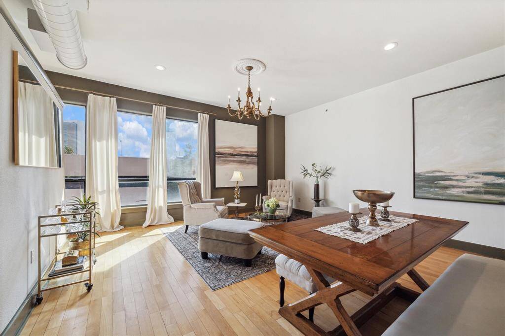 Bright and spacious living area with large windows for natural light & hardwood floors makes it an inviting space for relaxation and entertaining.
