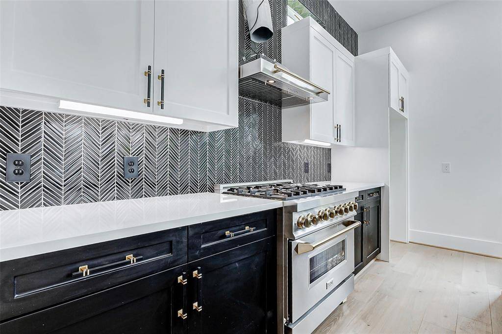 The modern black and white herringbone pattern adds texture and visual interest, tying together the sleek finishes and open-concept design for a space that's both stylish and highly functional."
