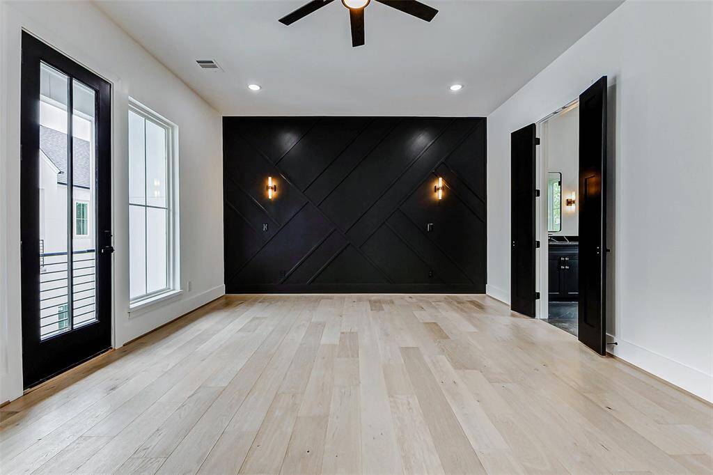 Retreat to this luxurious primary bedroom, where modern elegance meets comfort. With soaring ceilings and abundant natural light, the space feels both spacious and serene. The engineered hardwood floors add warmth, while the large windows offer a tranquil view of the surrounding area.