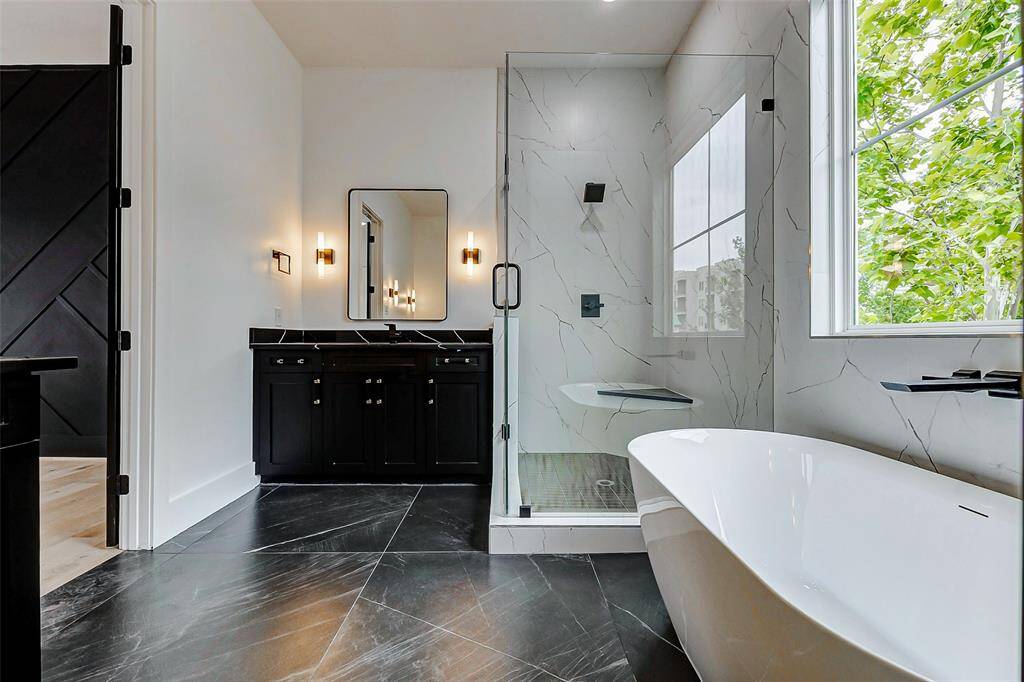 Black tile flooring adds a touch of modern elegance, creating a striking contrast that complements the high-end finishes throughout the space.
