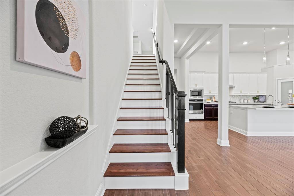 Wood staircase with wrought iron spindles.