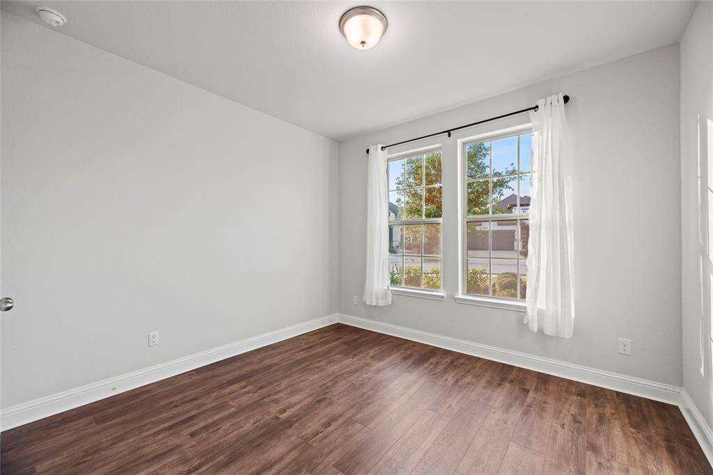 A convenient secondary bedroom is located downstairs with wood-look tile flooring and a walk-in closet.