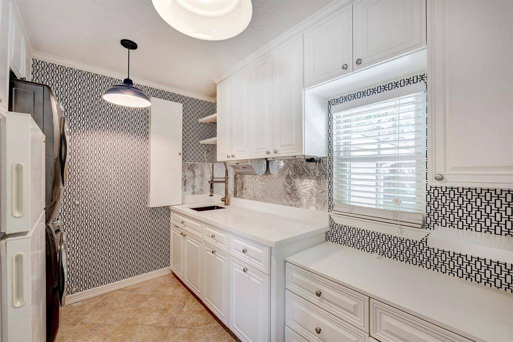 This is the utility room with a full size fridge, sink & washer and dryer. All appliances in the home remain. Great countertop area for holding books, mail, whatever!