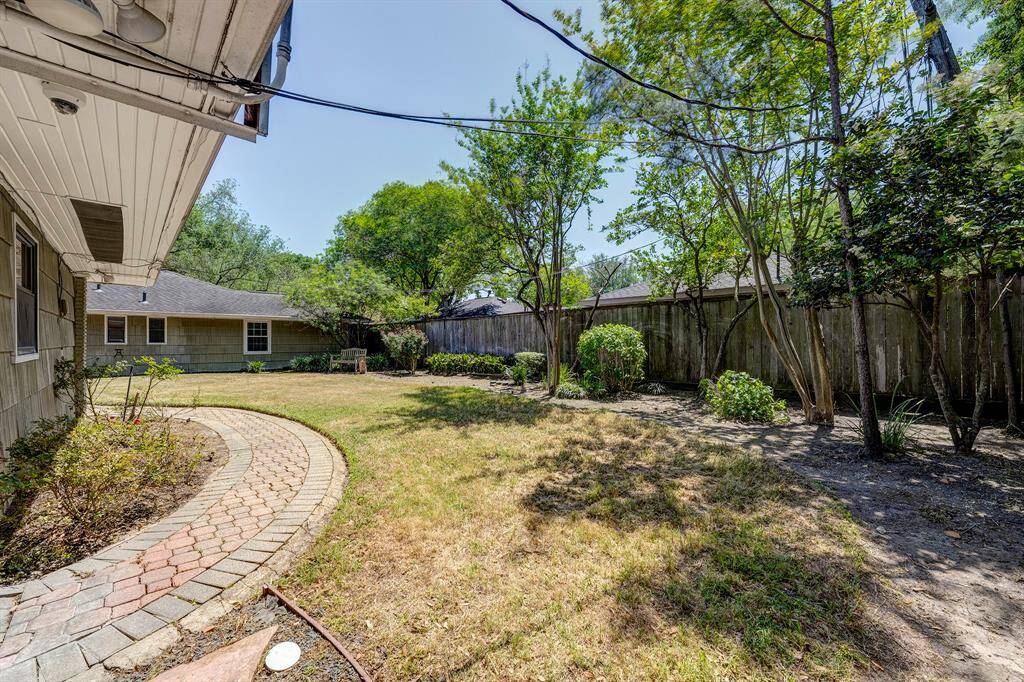 A good view of the home from the back of the property showcasing the depth of the lot & pretty brick path.