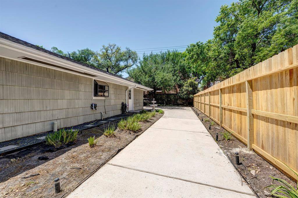 The freshly power washed single wide drive leading past the door to the kitchen to the garage.