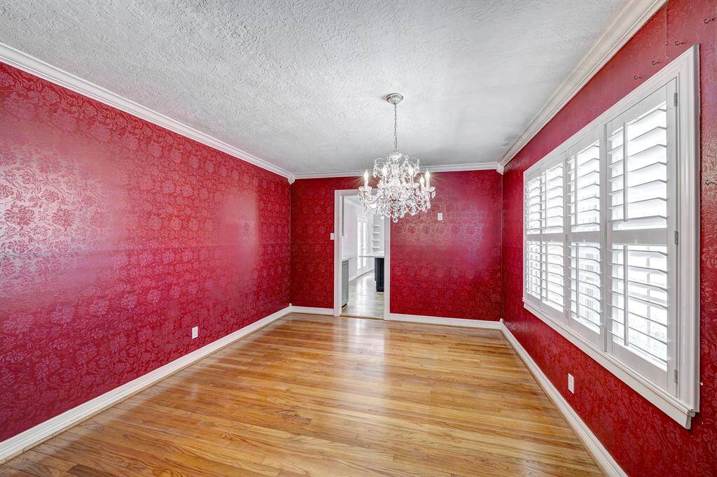 The dining room has an exceptional hand painted treatment on the walls, plantation shutters & lovely chandelier.