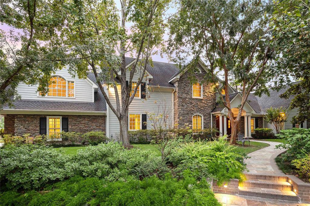 Nestled on the cul-de-sac, the house is softly illuminated in the remarkable outdoor setting.
