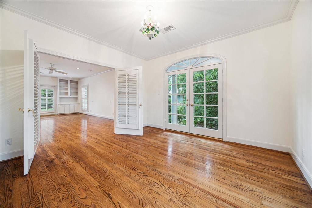 Exercise room within the primary suite is connected to the bedroom through double doors.