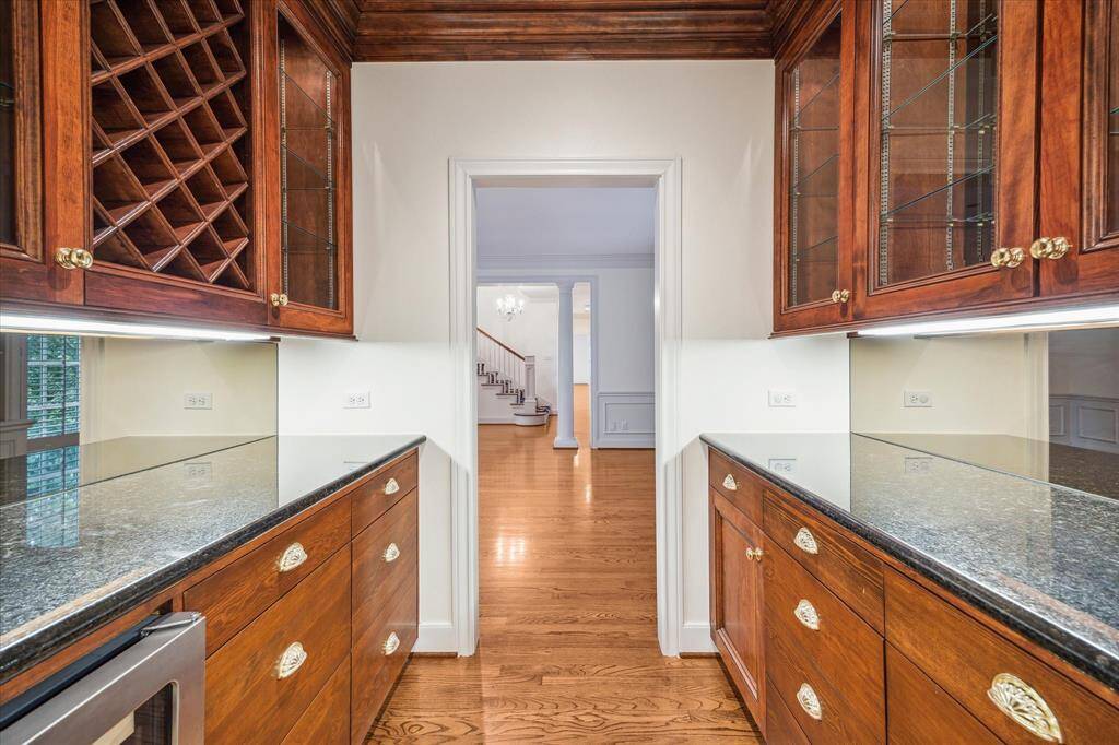 Butler's Pantry off the dining room with glass front upper cabinets, wine storage and fridge.