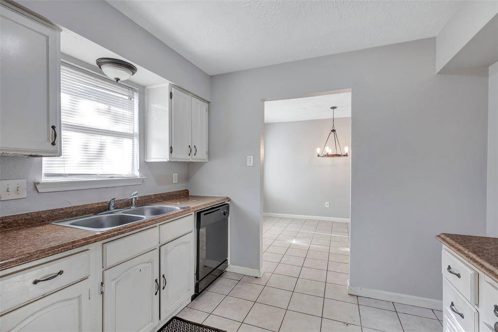 A view from inside the kitchen where you can catch a glimpse of the dining area through the open door.