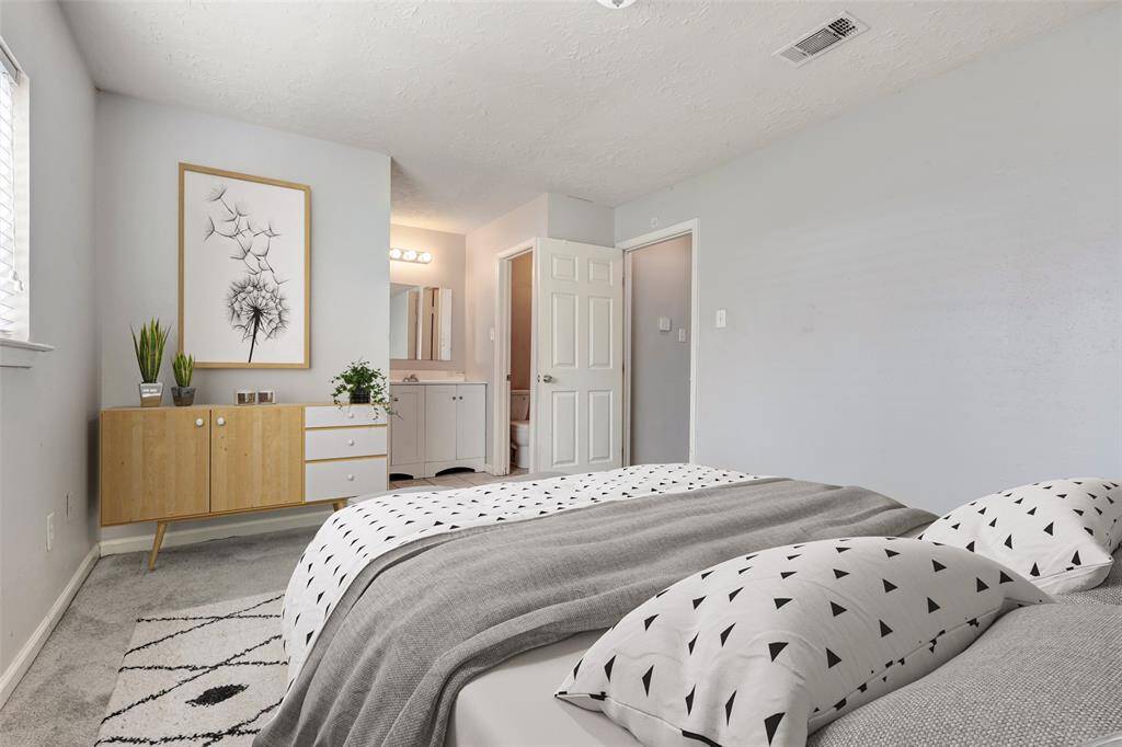 Inside the primary bedroom, you'll find a private en suite bath for added convenience, along with a spacious walk-in closet to the right, offering plenty of storage and organization. (Virtually Staged)