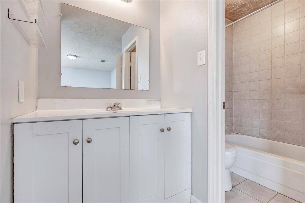 Step inside the primary bathroom, featuring a tub and shower combo for ultimate relaxation, along with a single sink for added convenience and functionality.