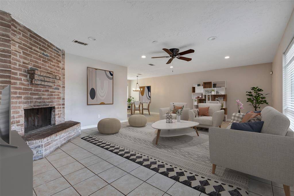 Step into a warm welcome as the inviting living room greets you with a charming wood-burning fireplace—the perfect centerpiece for cozy evenings and gatherings. (Virtually Staged)