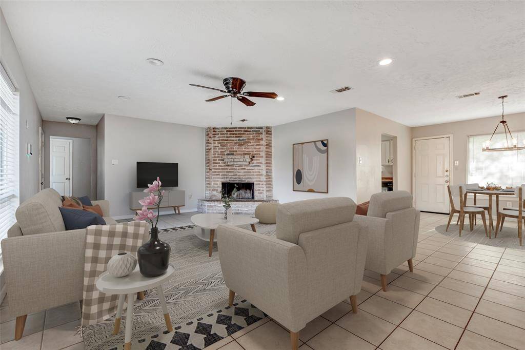 Elegant tiled flooring flows seamlessly throughout the living area, dining space, and kitchen, offering a clean, cohesive look that's both stylish and easy to maintain. (Virtually Staged)