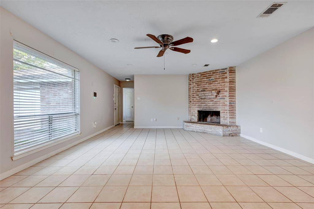 A large window fills the living room with natural light, creating a bright and airy atmosphere.