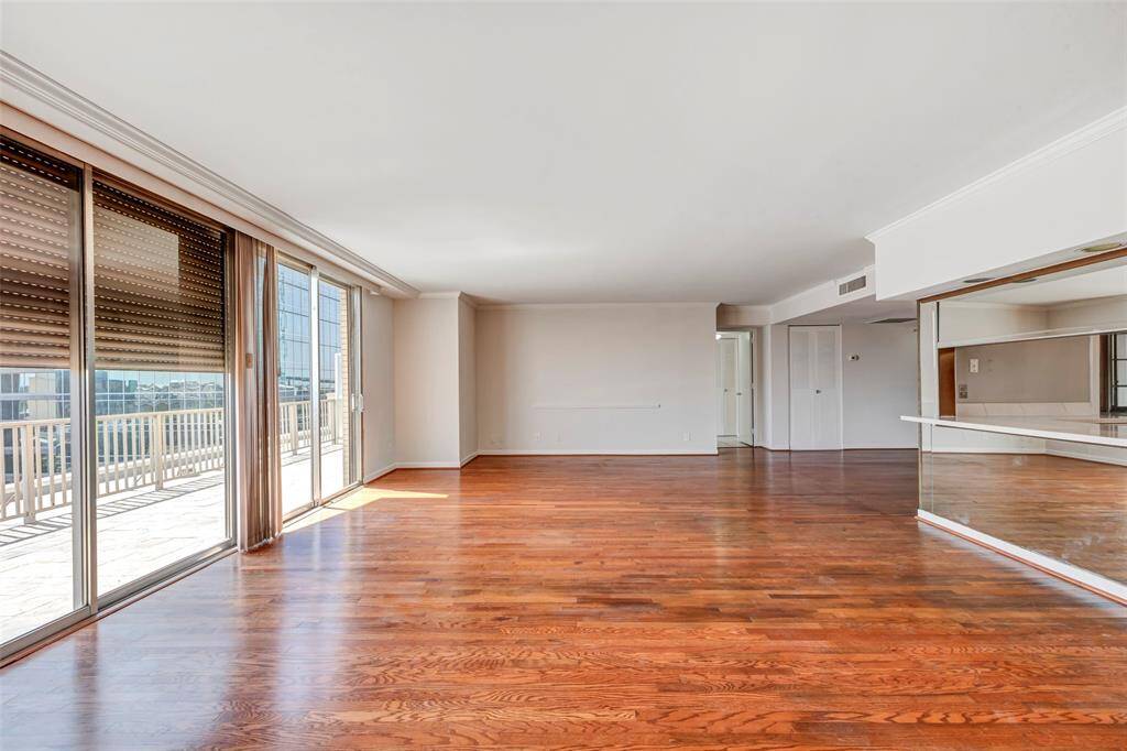 End view of the living room, beautifully illuminated by floor-to-ceiling sliding glass doors that bring in natural light and offer easy access to the outdoors.