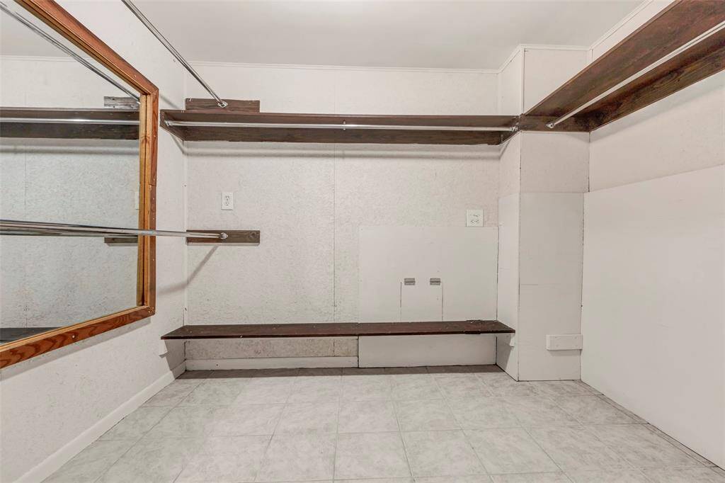 Spacious walk-in closet featuring plenty of storage and a large mirror for added convenience and style.