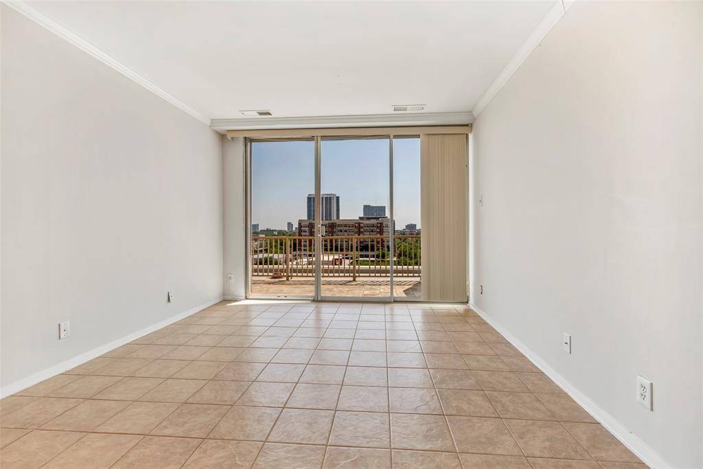 Secondary bedroom with tiled flooring and glass sliding doors that lead to the terrace, offering great natural light and outdoor access.