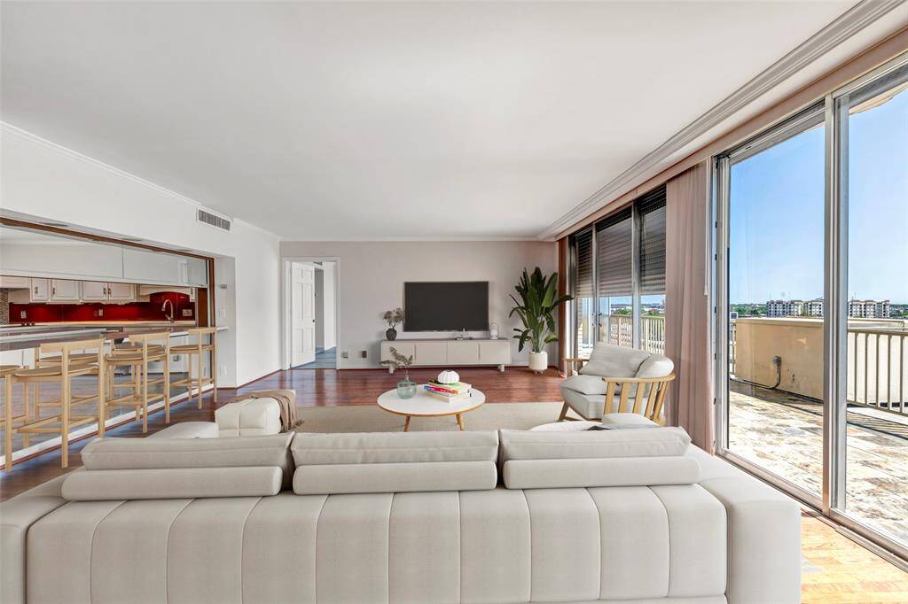 Bright and airy living room featuring expansive sliding glass doors and seamless access to the terrace—perfect for indoor-outdoor living. (Virtually Staged)