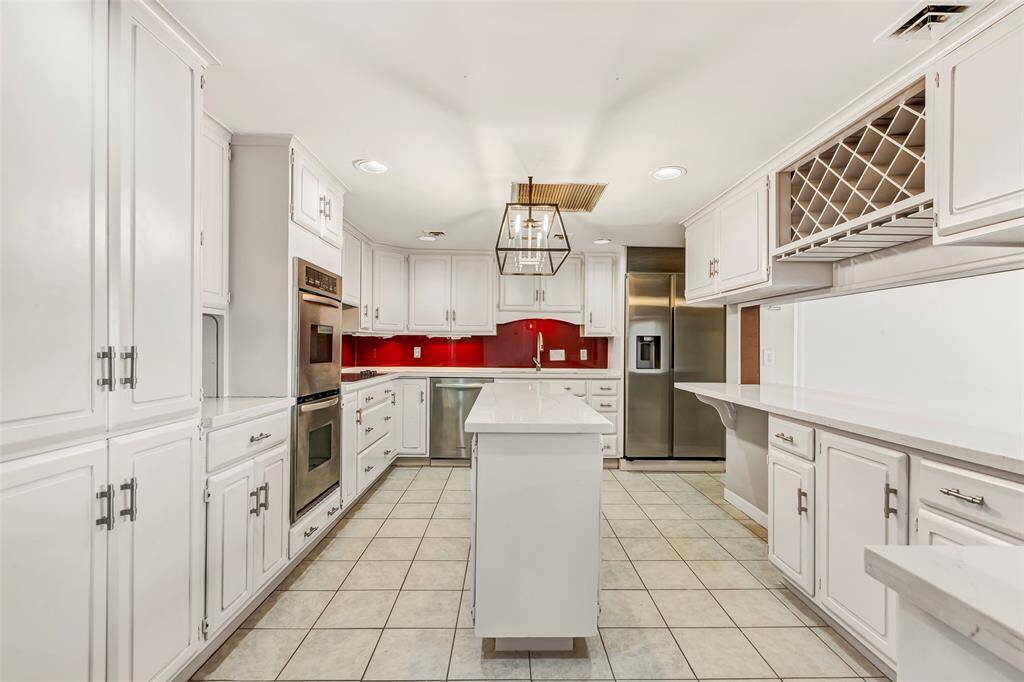 Another view of the kitchen highlights its functional layout, ample cabinet storage, and sleek stainless steel appliances.