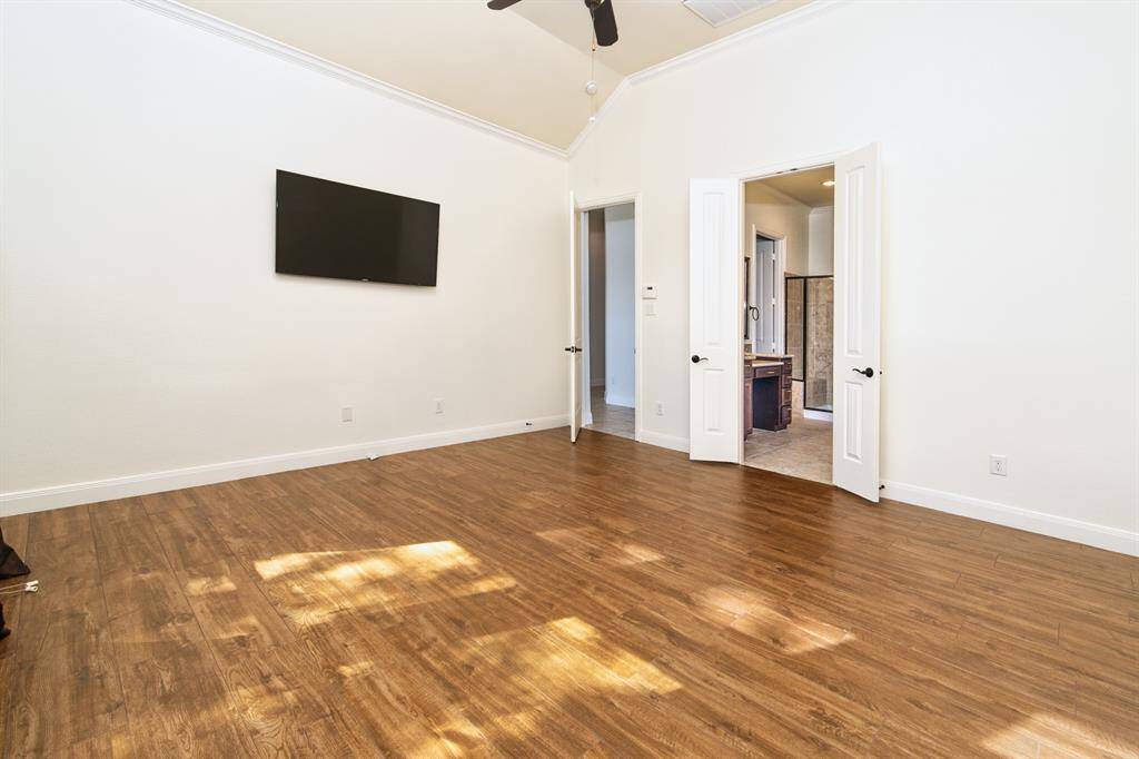 Entertainment-ready master bedroom with a large TV.