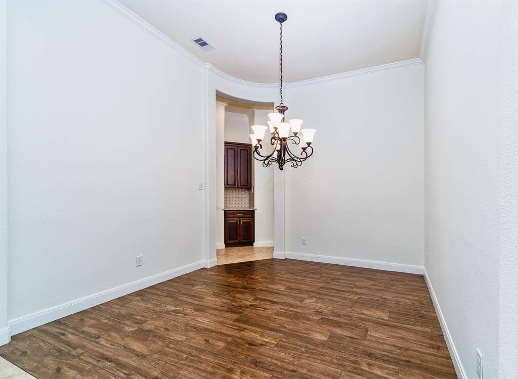 Sophisticated formal dining room with a chandelier and a butler’s pantry.