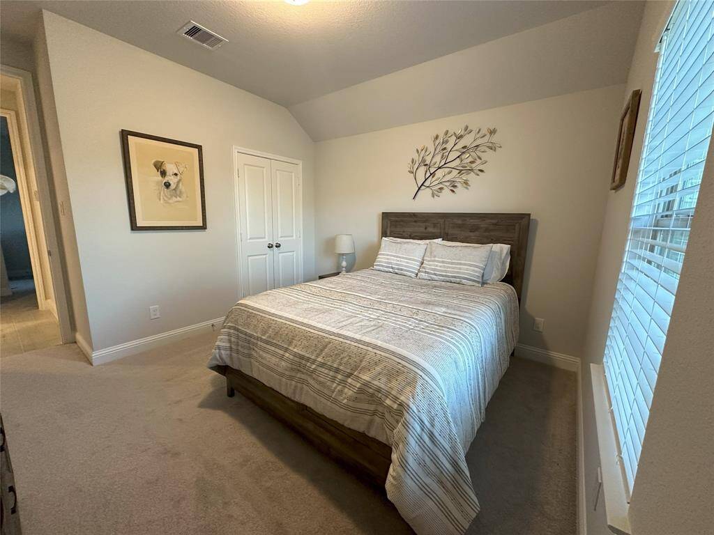 Secondary bathroom with elegant marble countertops, a single sink, and a tub/shower combo. Additional storage provided by a convenient linen closet.