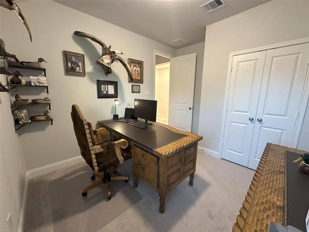 Convenient utility room with ample space for laundry, featuring built-in shelving for storage and room for a washer and dryer.