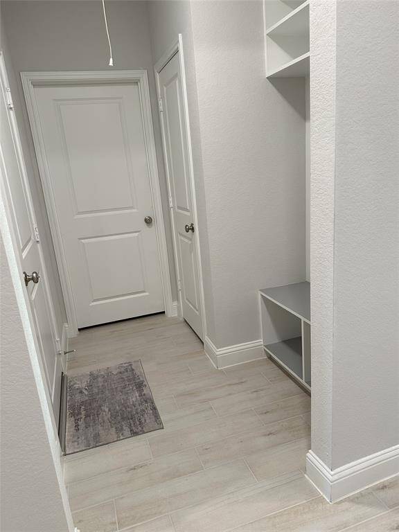 Two-car garage with durable epoxy floors, offering plenty of space for parking and storage. Please note, cabinets and hanging shelves are not included.