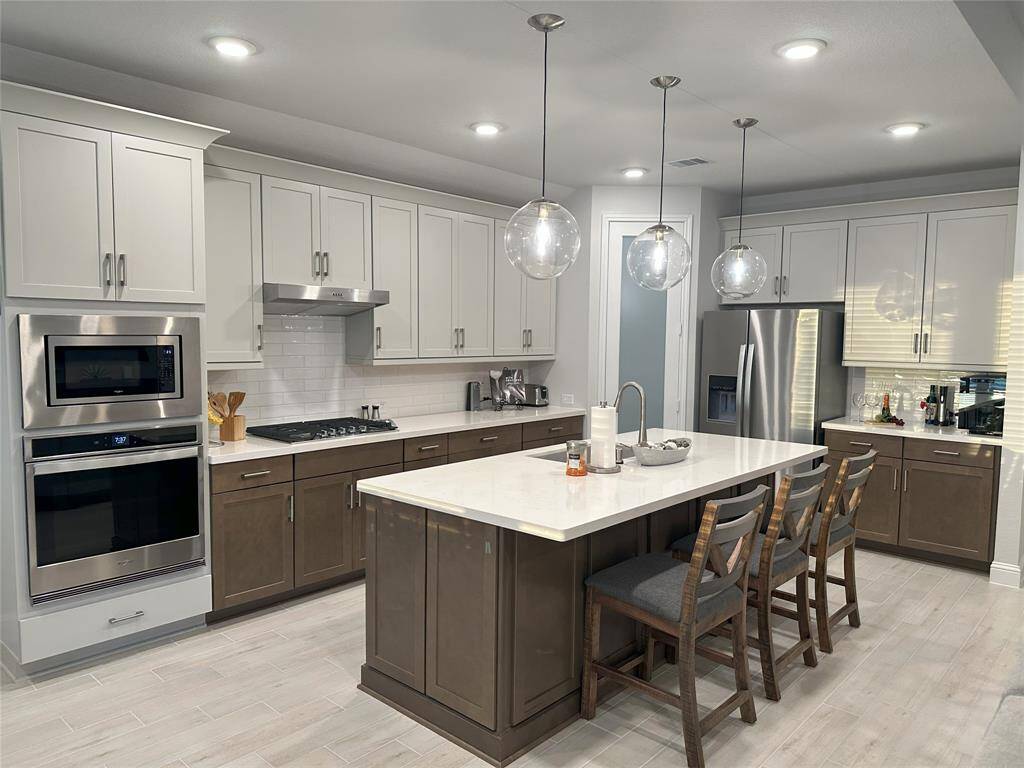 Modern kitchen with sleek stainless steel appliances and ample cabinet space.