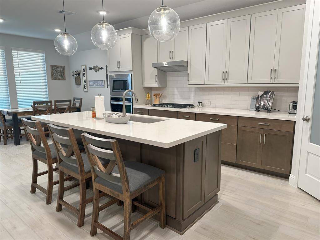 Generous island features a breakfast bar, perfect for relaxed morning dining.