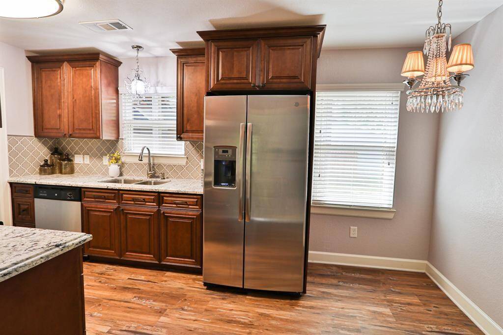 The dark wood cabinetry adds warmth and elegance, beautifully contrasted by a neutral-tone geometric tile backsplash.