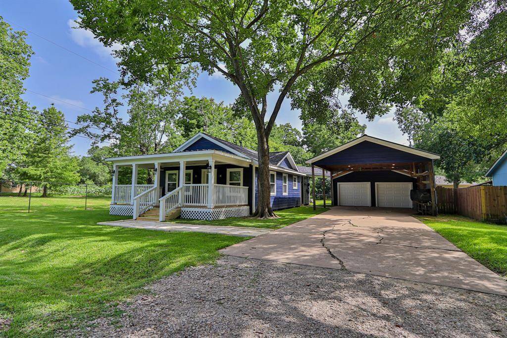 Outside, the lush, manicured lawn and mature shade trees create a peaceful retreat, while a spacious driveway leads to a detached two-door garage with a covered carport.