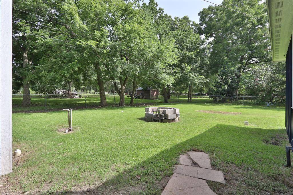 The backdrop of mature trees and rich foliage enhances the serene atmosphere, providing shade and privacy.