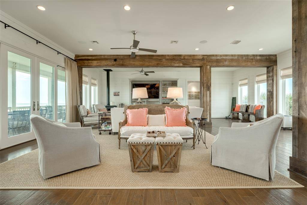 Two walls of windows provide views of the beach and the Bay and are covered with high-end custom drapery and blinds