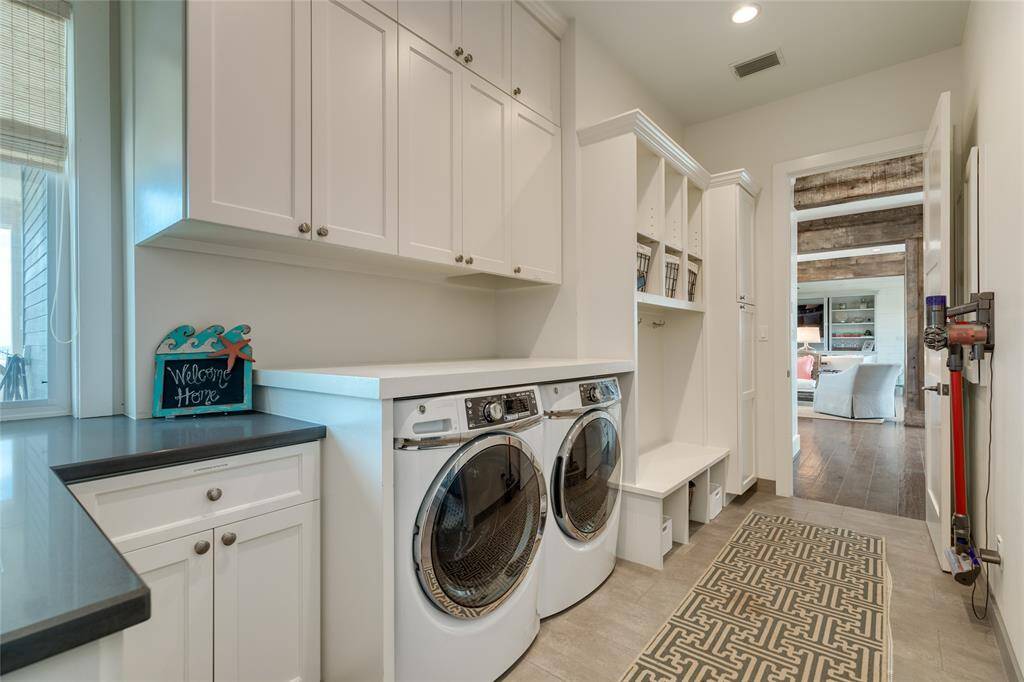Large utility/mud room can also be accessed from the front porch. Features include a laundry chute; built-in cubbies & bench; bar-height counter over the washer/dryer for easier folding; walk-in shower (not seen but to the right)