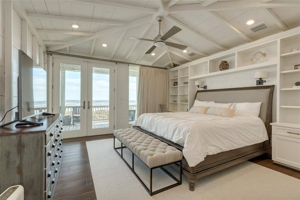 Gorgeous Primary Bedroom has a vaulted ceiling with exposed beams, and a built-in desk and shelving