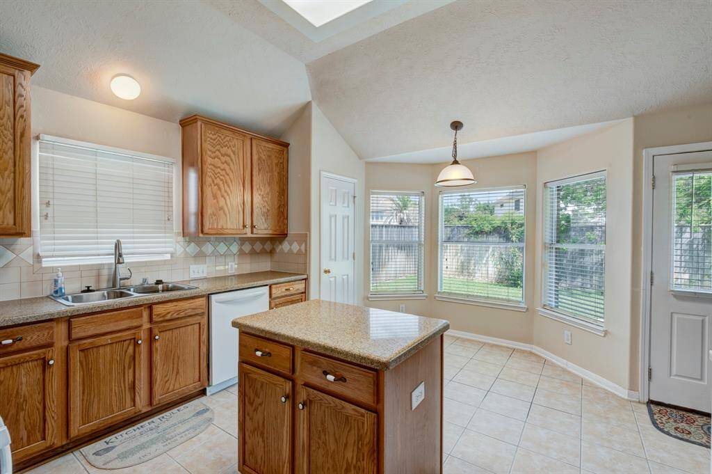 A cheery breakfast area is filled with light by the bay window looking out over the backyard. Noticing convenient access to the back patio for cooking out.