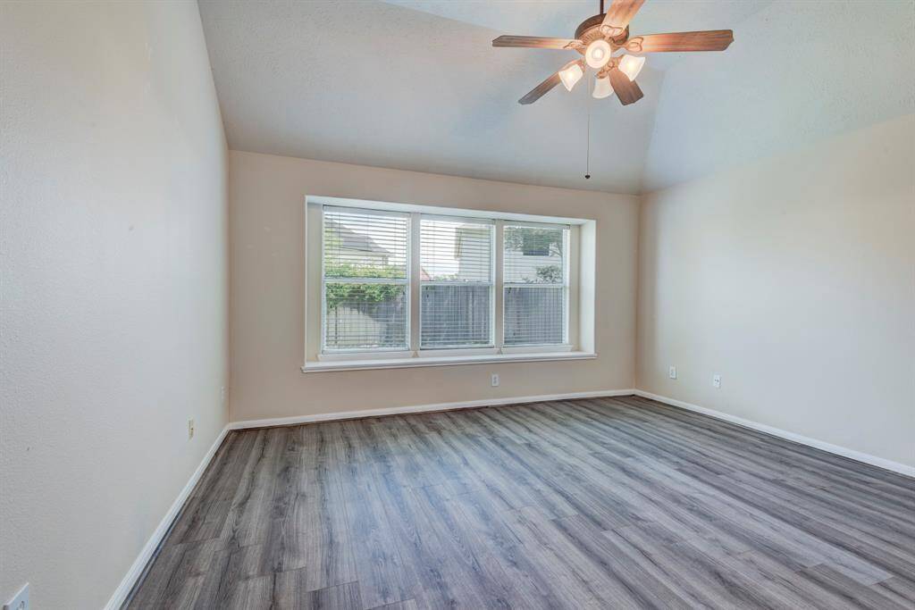 Primary suite - This wood-look flooring flows throughout the living room, hallway and bedrooms. No carpet in this home.
