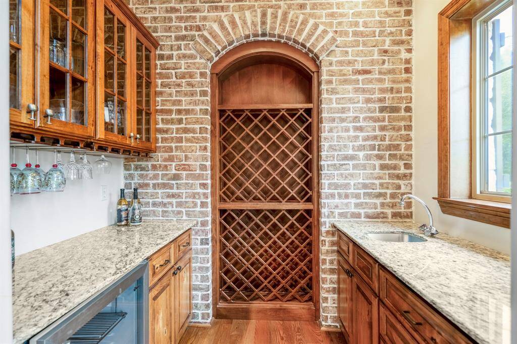 Charming brick accent wall highlights elegant wine storage.